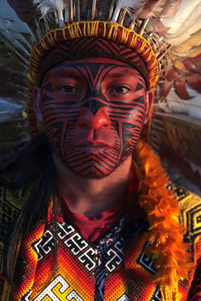 Mapu Huni Kuin com pintura de urucum e cocar